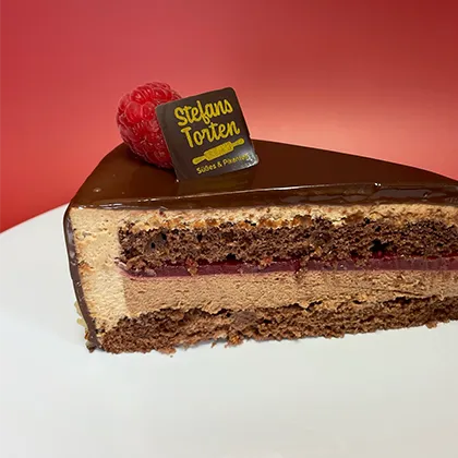 ein Stück Himbeertorte mit Stefans Torten Logo